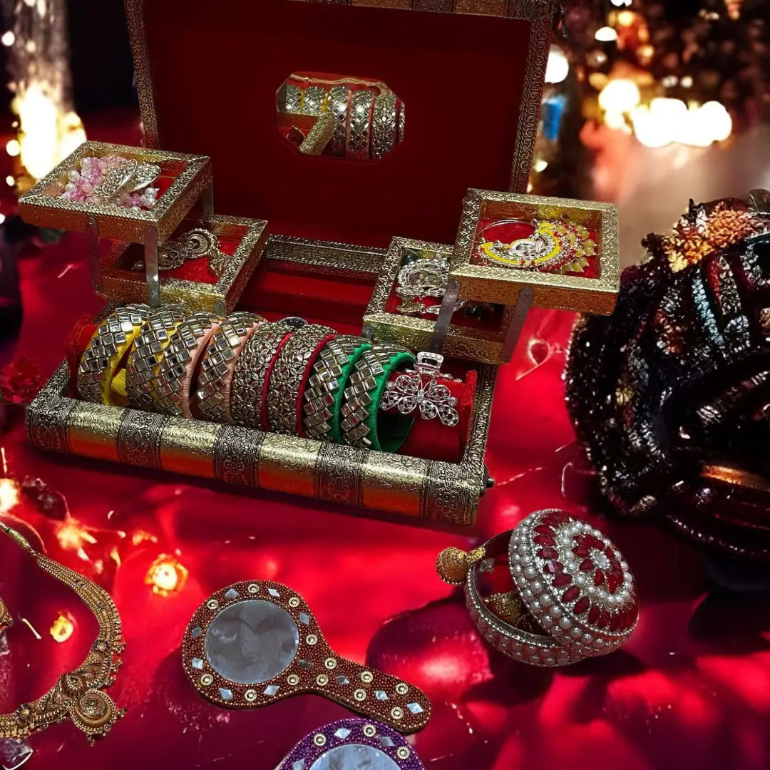 Colorful decorative cylinders with embroidered patterns and circular openings in an Indian jewellery box