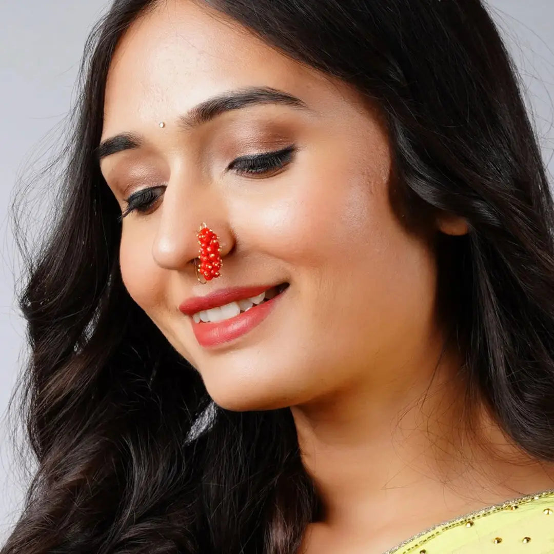 Close-up of a woman wearing a distinctive Indian nose pin with a red nose ornament and precious stones