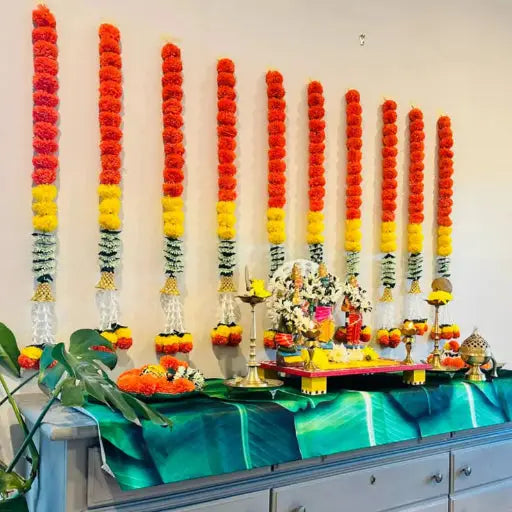 A beautifully decorated Indian home entrance with a colorful rangoli, flowers at the doorway, and a brass Durga idol, radiating warmth and celebration.