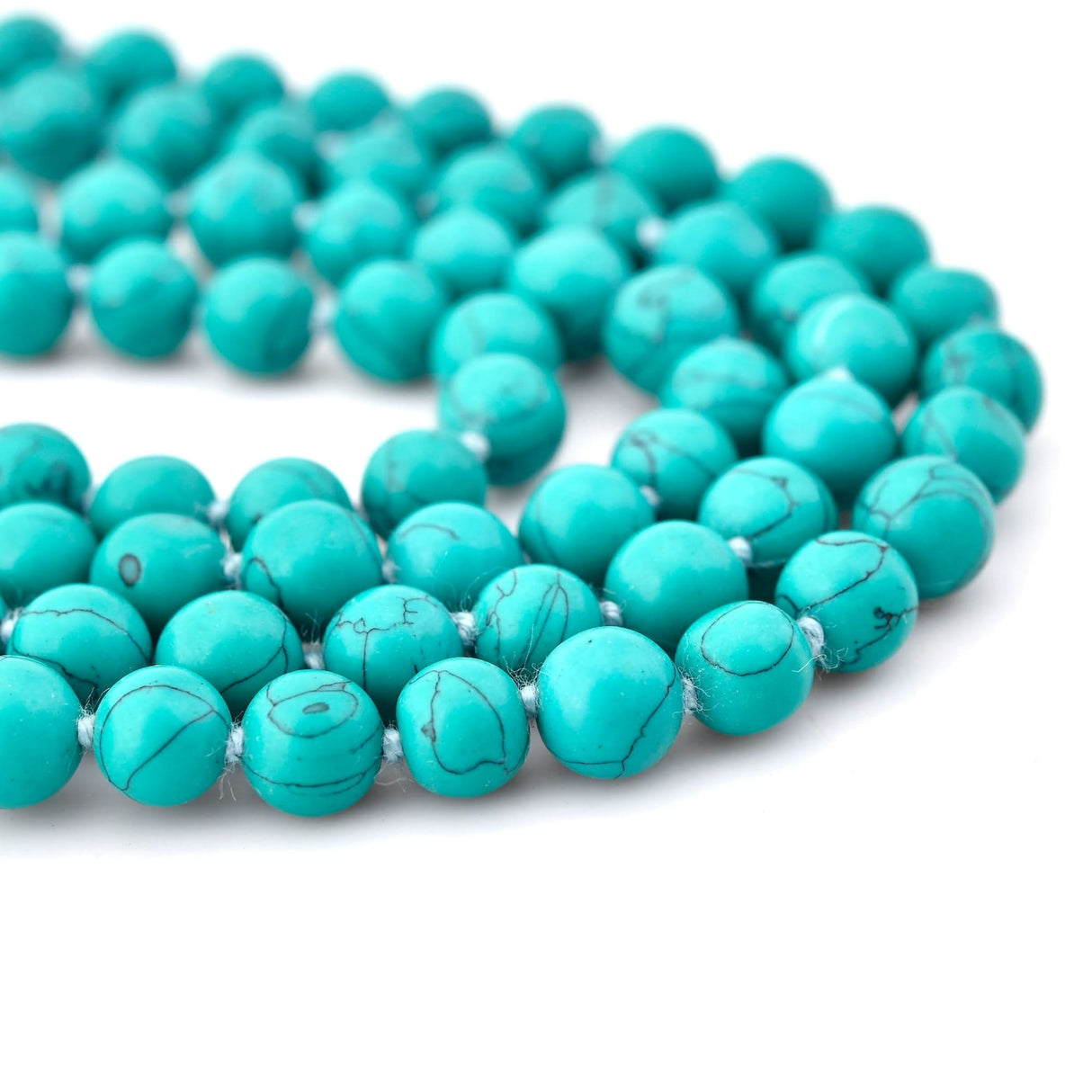 Polished turquoise mala beads with natural black matrix patterns for meditation and healing