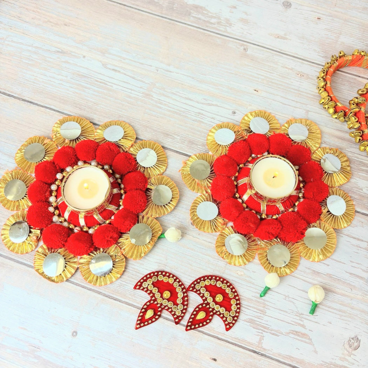 Red and gold decorative candle holders with mirrors for Diwali and festive celebrations