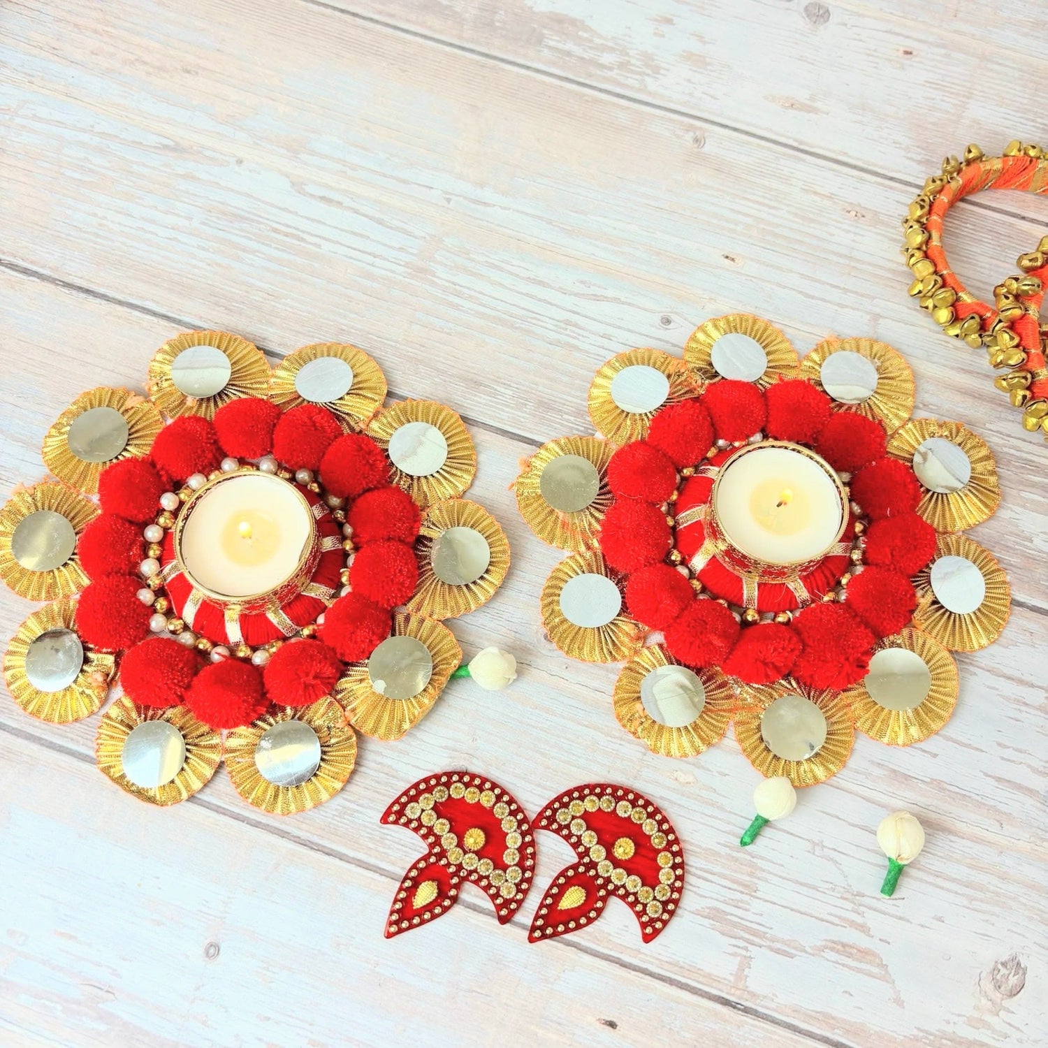 Red and gold decorative candle holders with mirrors for Diwali and festive celebrations