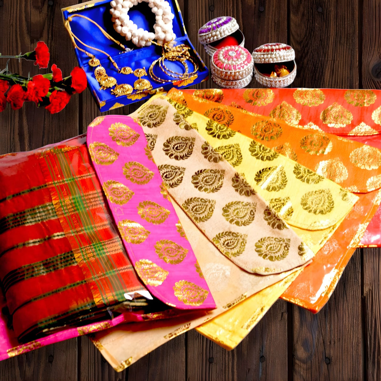 Vibrant pink yellow and orange silk brocade sari bags with gold paisley designs and zipper closure for wardrobe storage and gifting