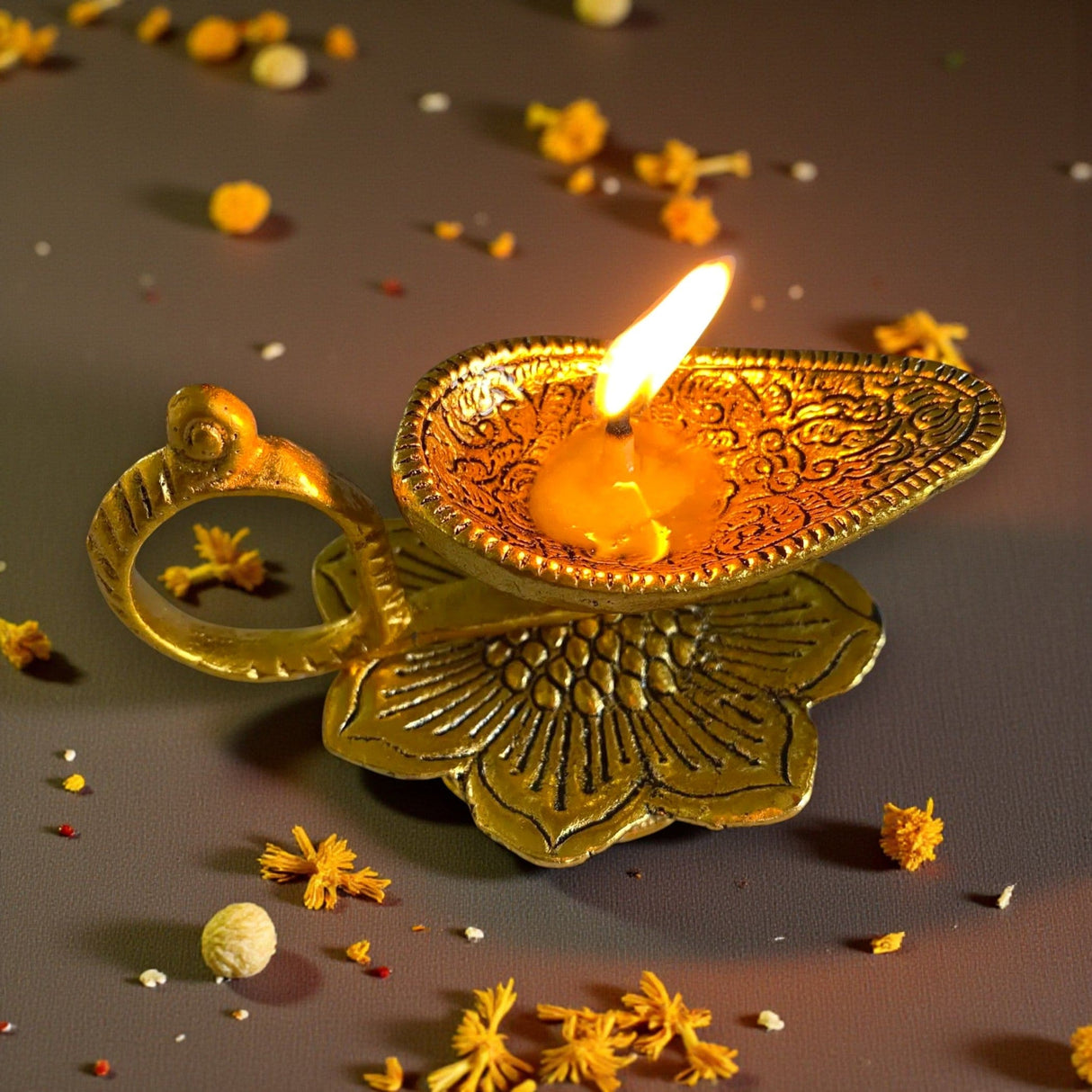 Golden ornate Lotus brass diya oil lamp with lit candle for Diwali puja
