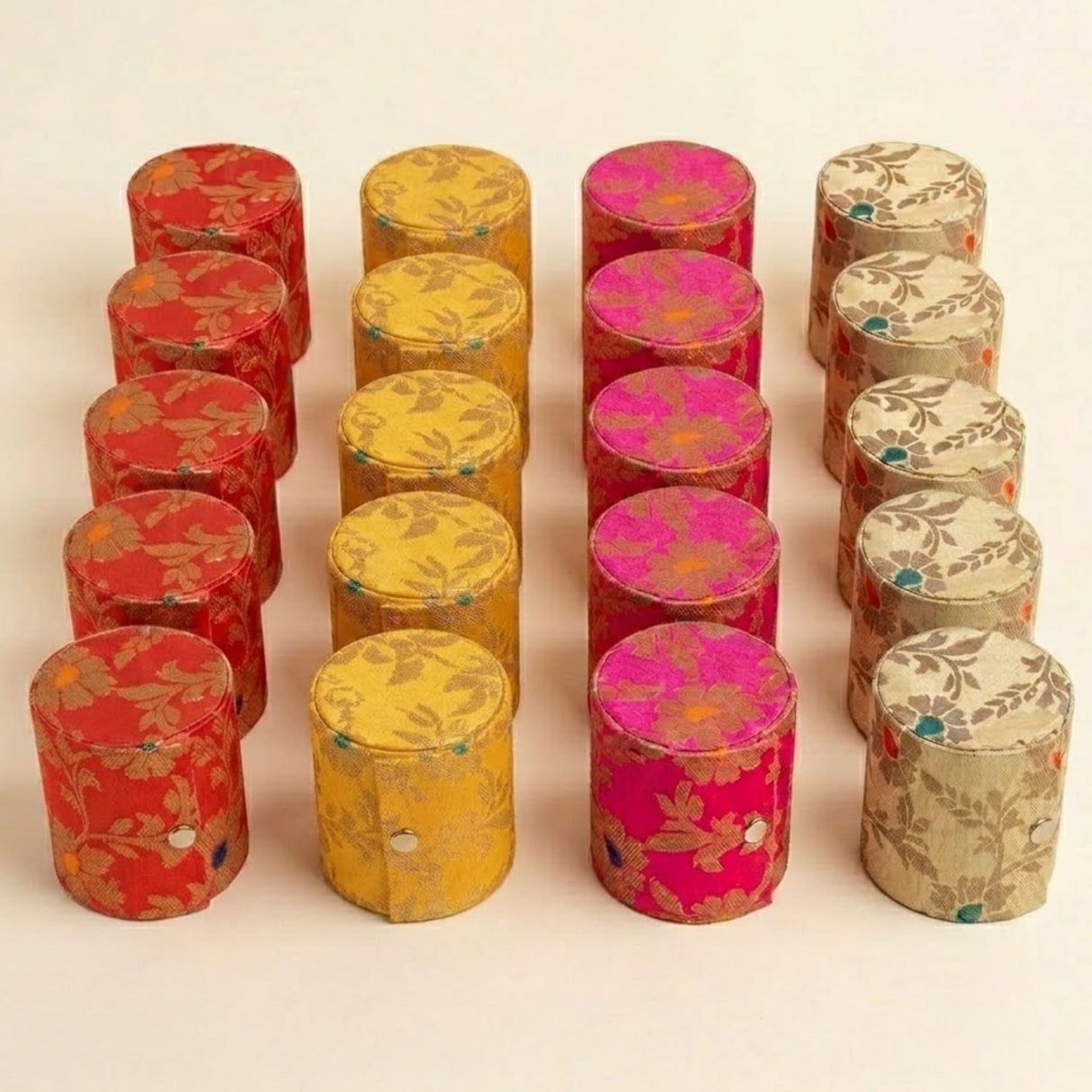 Vibrant cylindrical bangle box organizer in red yellow pink and beige satin fabric with intricate floral patterns for travel and gifts