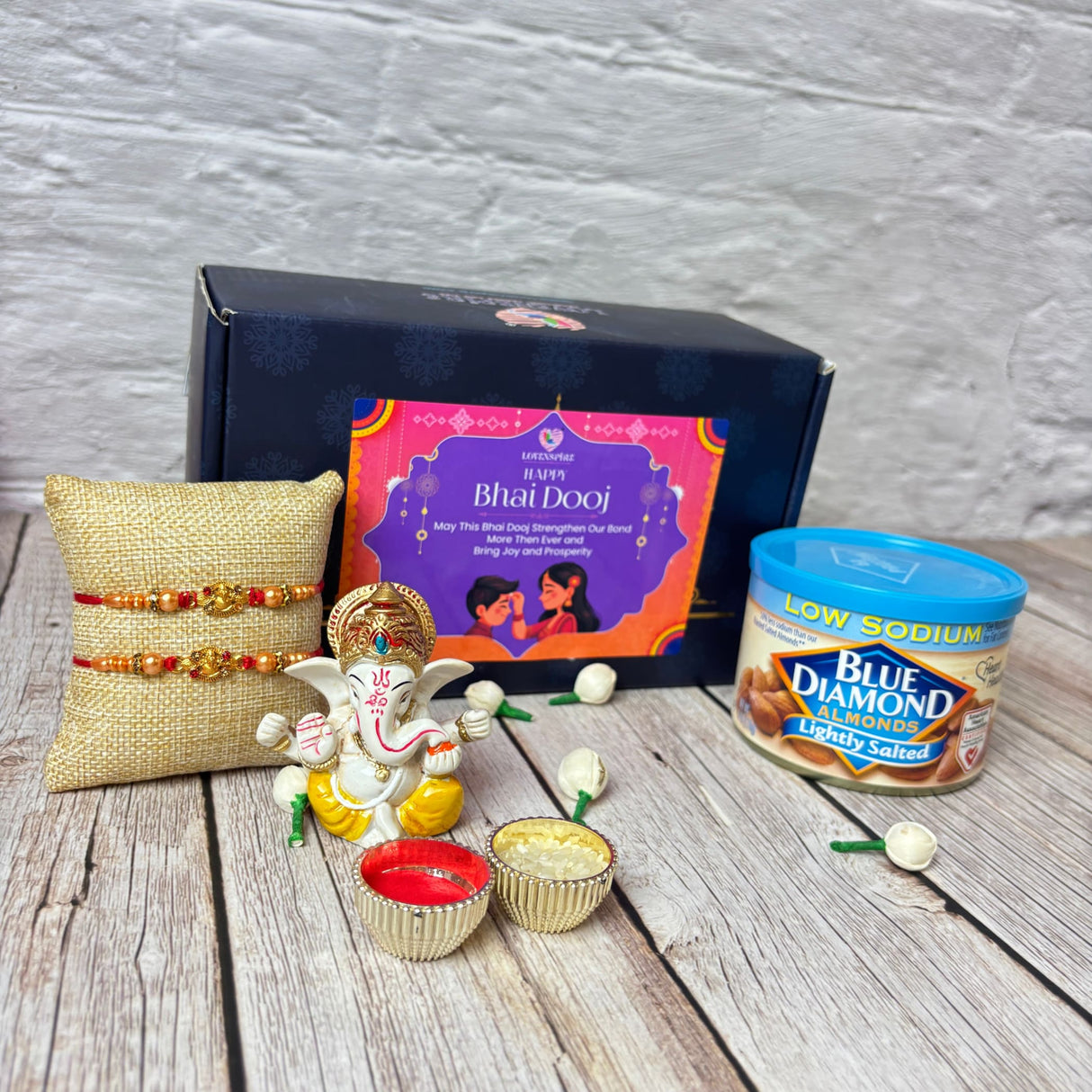 Bhai Dooj gift set with Ganesha idol, rakhis, bowls, and Blue Diamond almonds