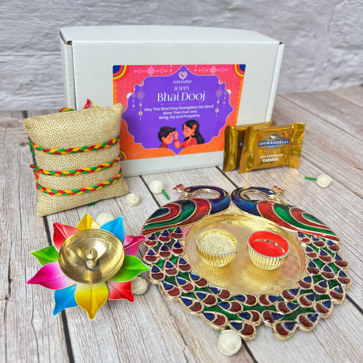 Bhai Dooj gift set with decorative thali, diya, pillow, chocolates, and rakhi for brother