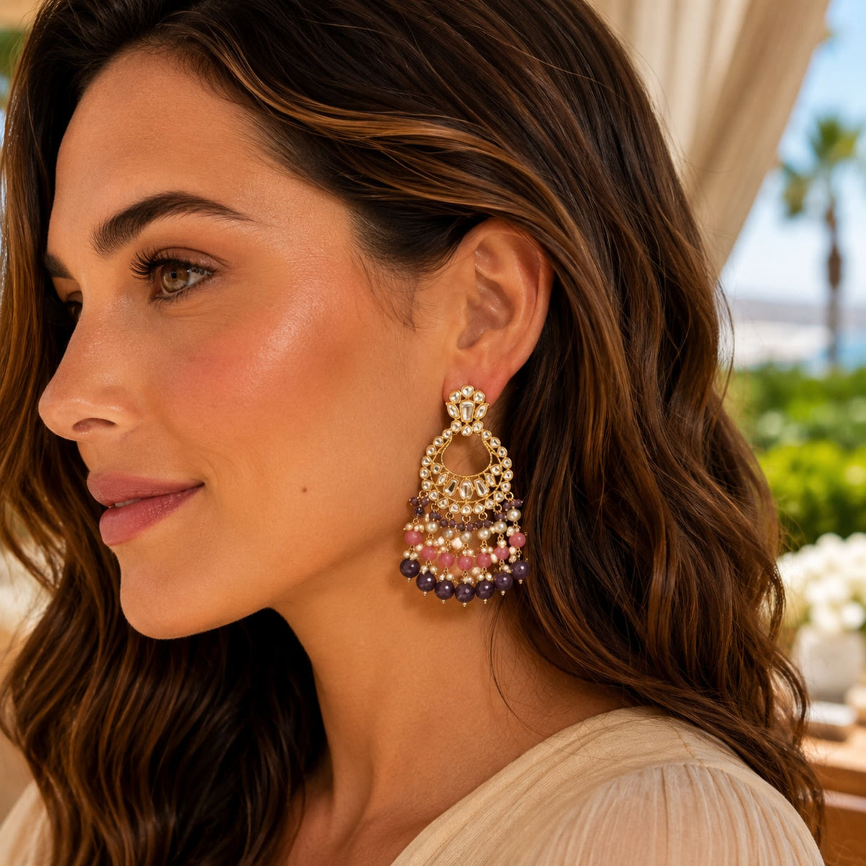 Oversized Indian kundan gold tone chandelier earrings with intricate metalwork and cascading pink and purple beads for ethnic wear