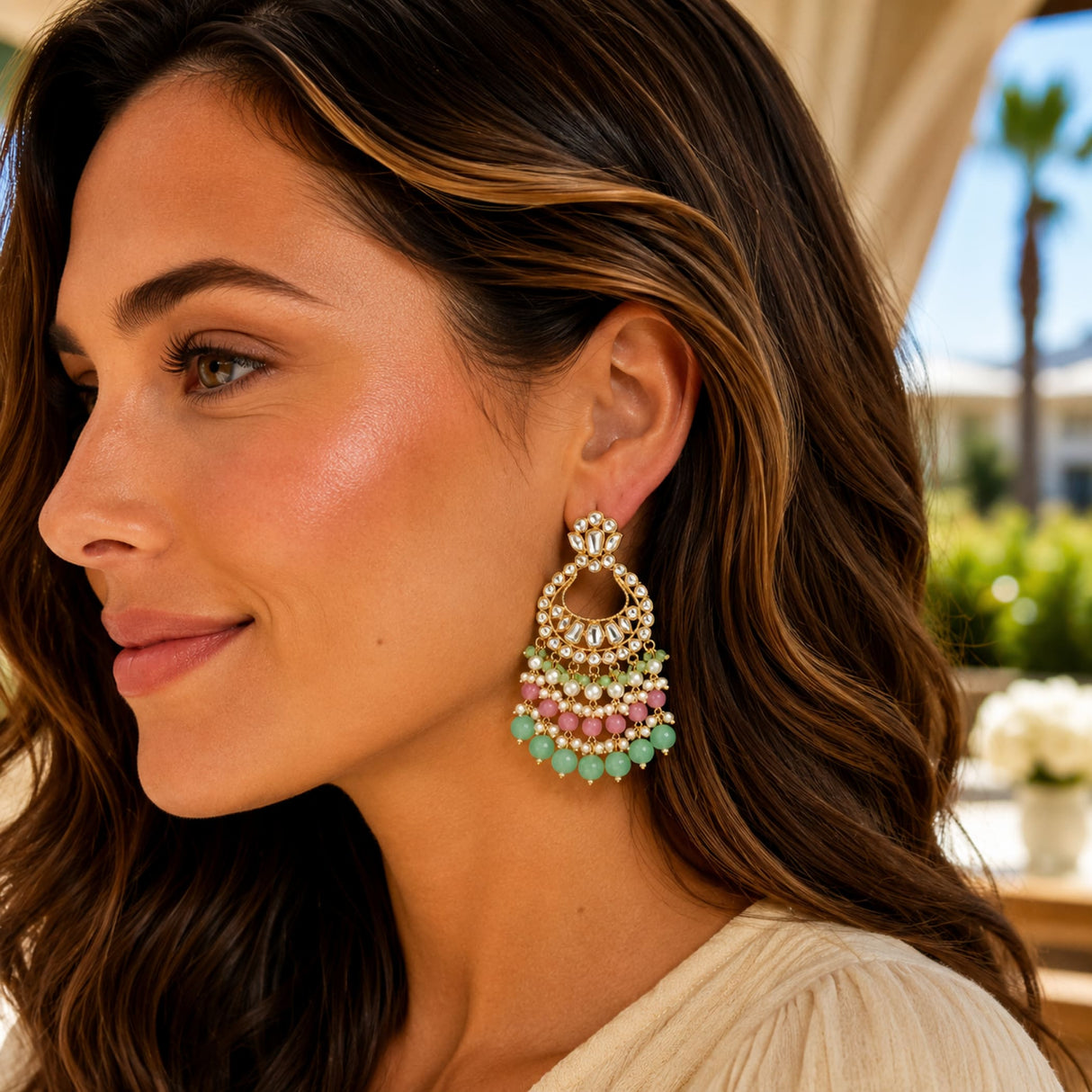 Delicate gold tone oversized Indian kundan chandelier earrings with pastel green pink beads and clear crystals for ethnic wear