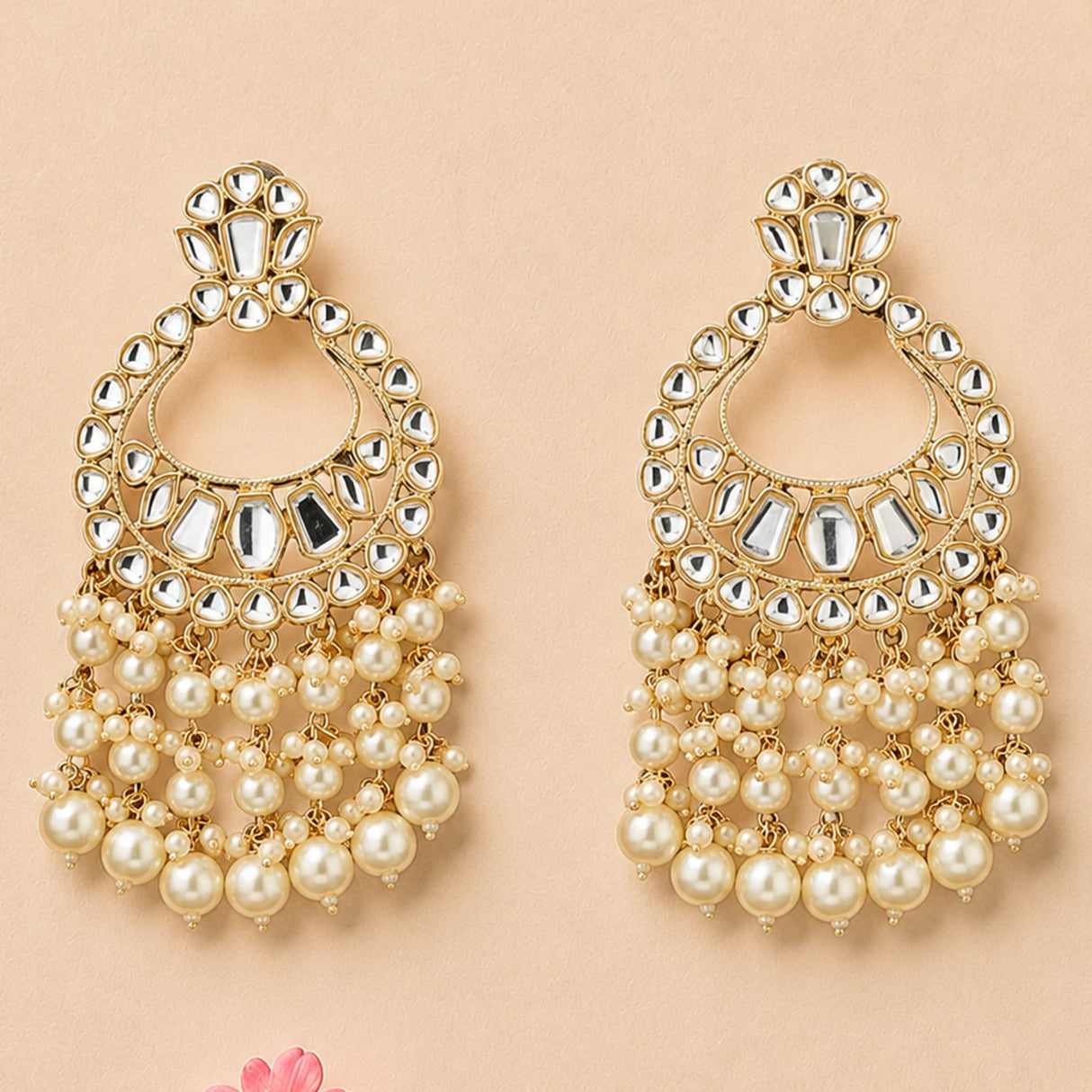 Gold tone oversized Indian kundan chandelier earrings with intricate mirror and faux pearl details for ethnic wear