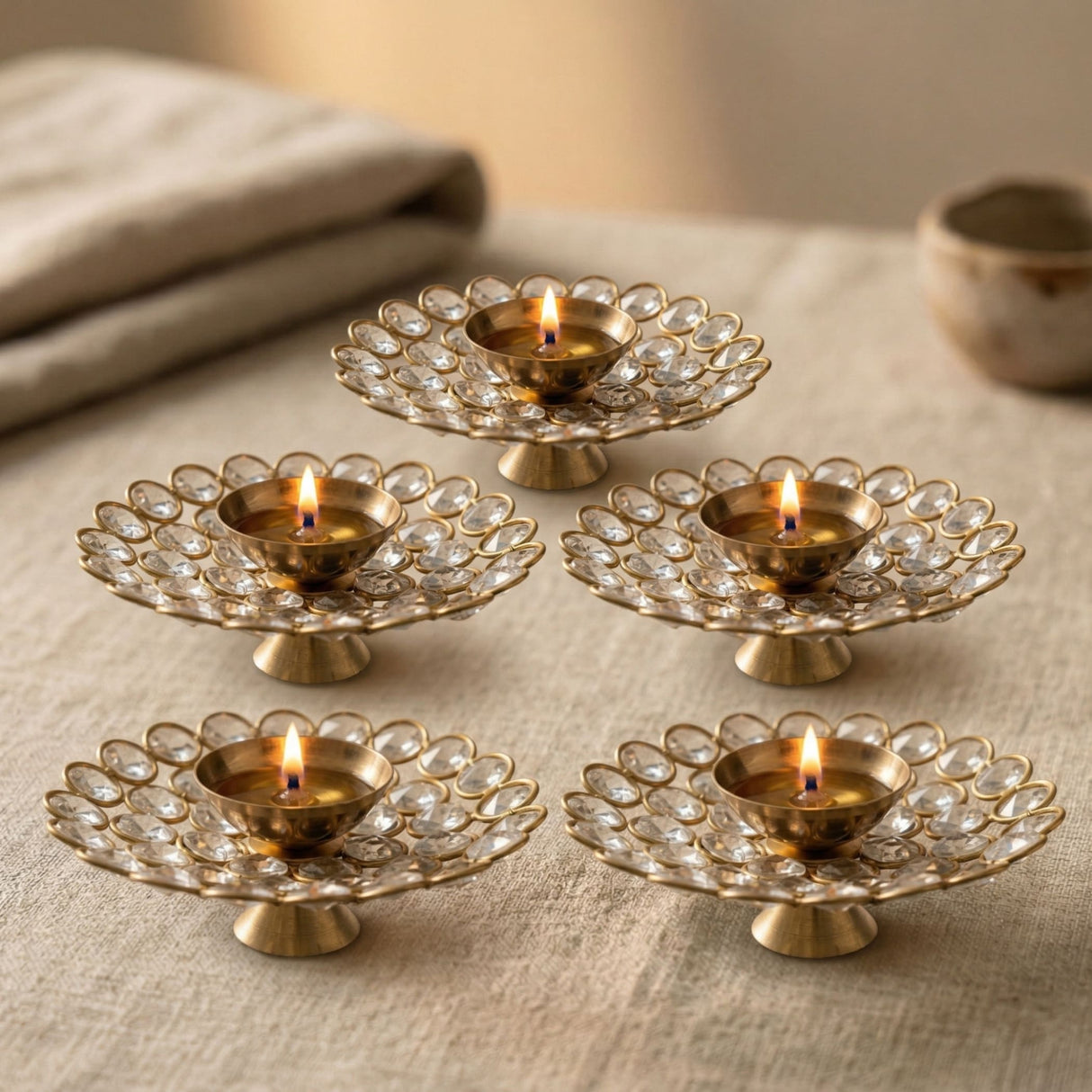 Gold-colored brass decorative diya lamps with acrylic glass floral design and clear crystal embellishments for Diwali puja