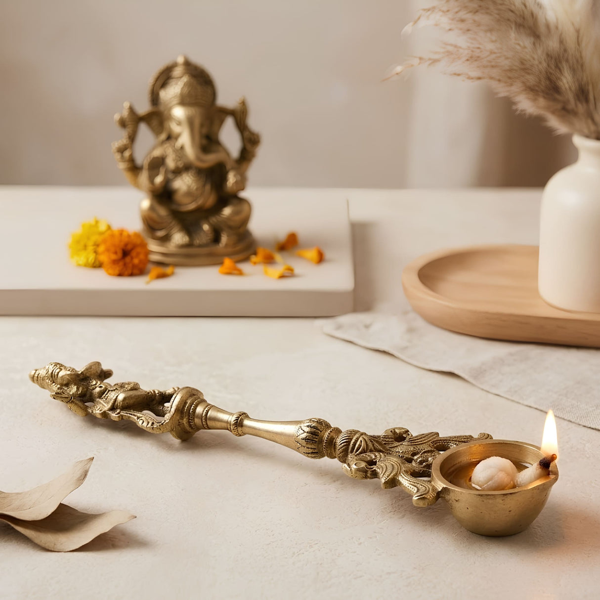 Golden brass decorative oil lamp with intricate carvings and lit flame for indian cultural religious decor and diwali gift