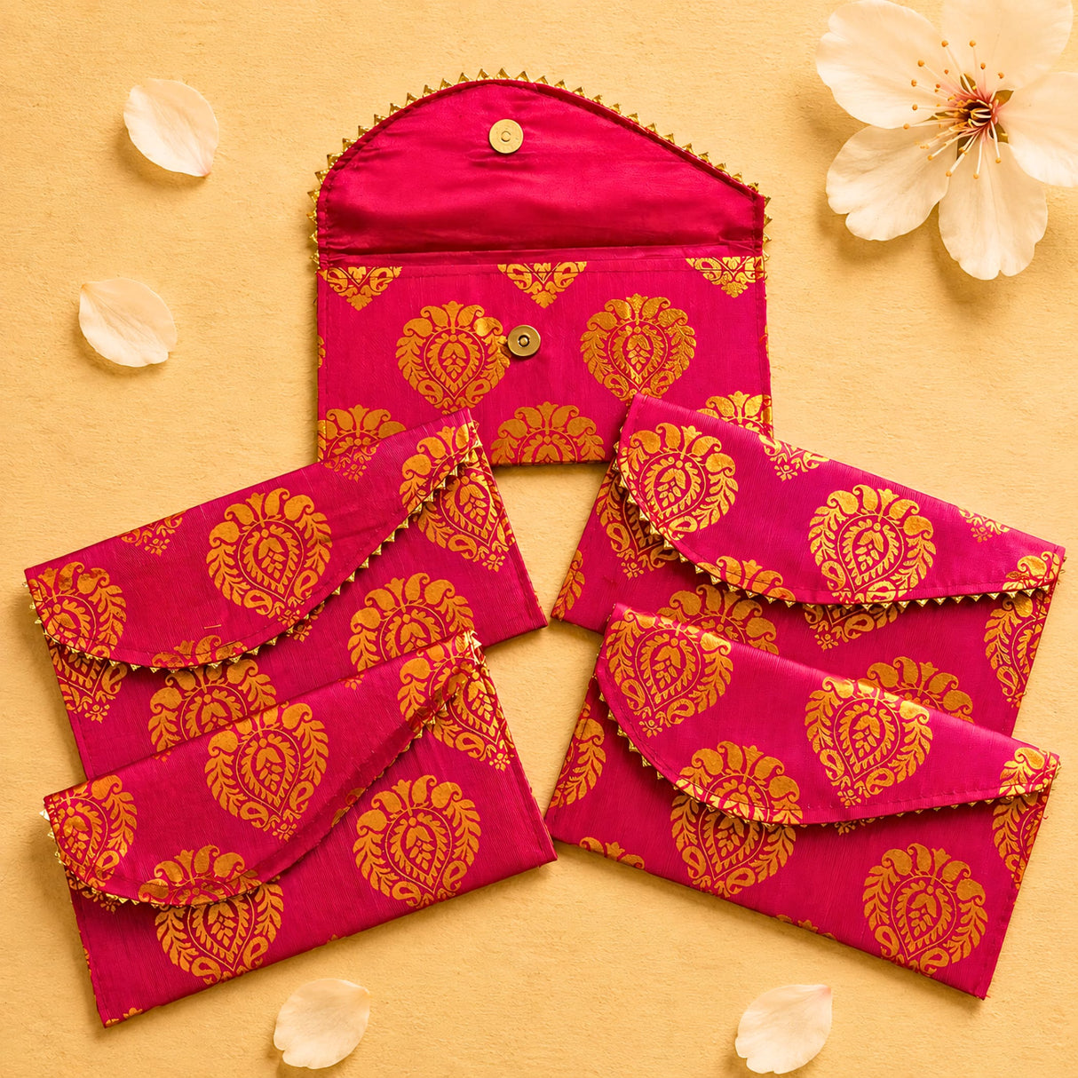 Brocade fabric money envelopes in vibrant fuchsia with gold paisley pattern and decorative button closures for gifting