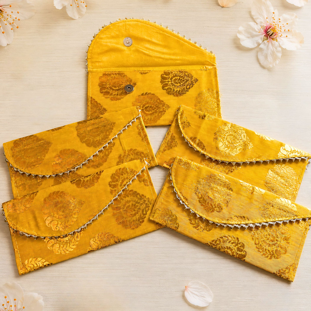 Brocade fabric money envelopes in bright yellow with gold floral embroidery and silver beaded edges for Indian weddings
