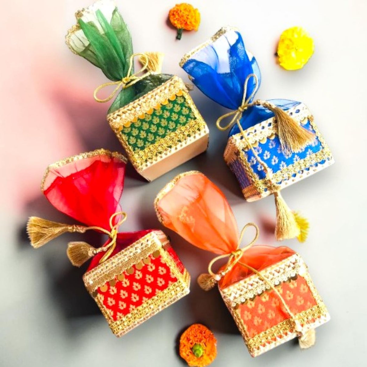 Colorful brocade potli gift boxes with gold trim tassels organza top for traditional Indian wedding favors and jewelry storage