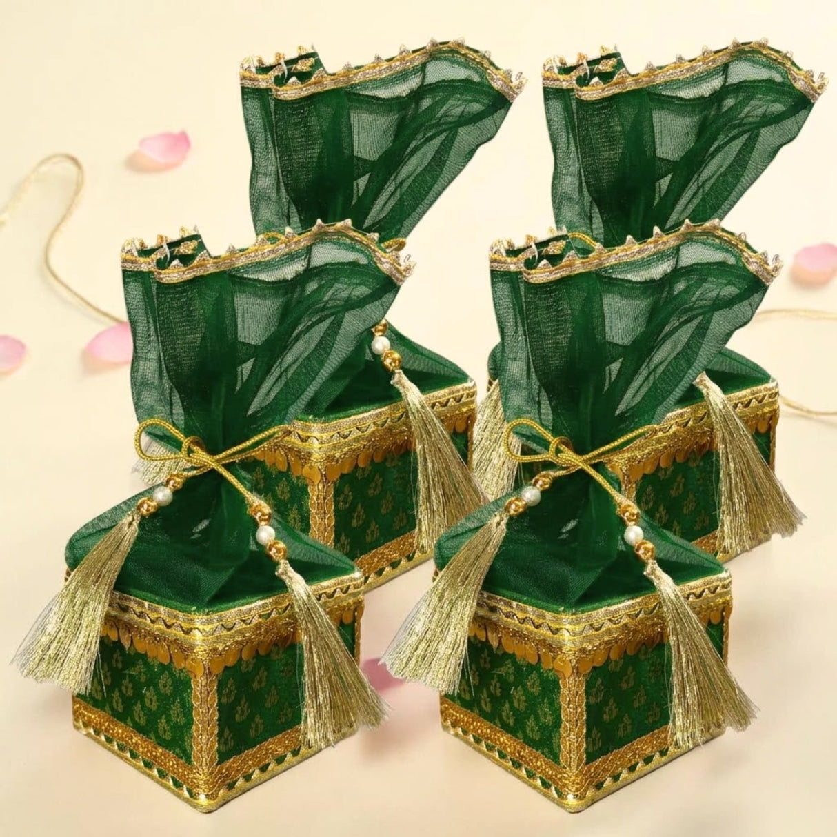 Emerald green velvet brocade potli gift boxes with gold trim and organza lids tied with pearl tassels for wedding favors