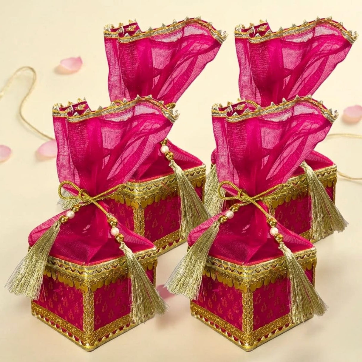Fuchsia sheer organza brocade potli gift boxes with gold-trimmed edges and tassels for traditional Indian weddings