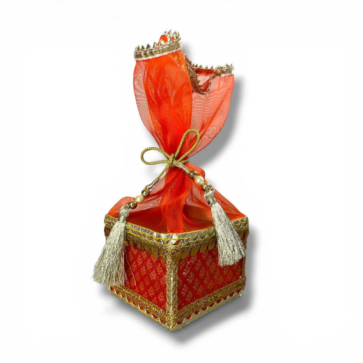 A vibrant red brocade potli gift box with gold trim tassels and organza top for traditional indian wedding favors
