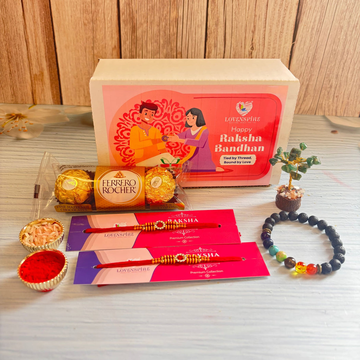 Designer rakhi gift hamper featuring a red rakhi with gold and silver decorative beads for brother and bhabhi