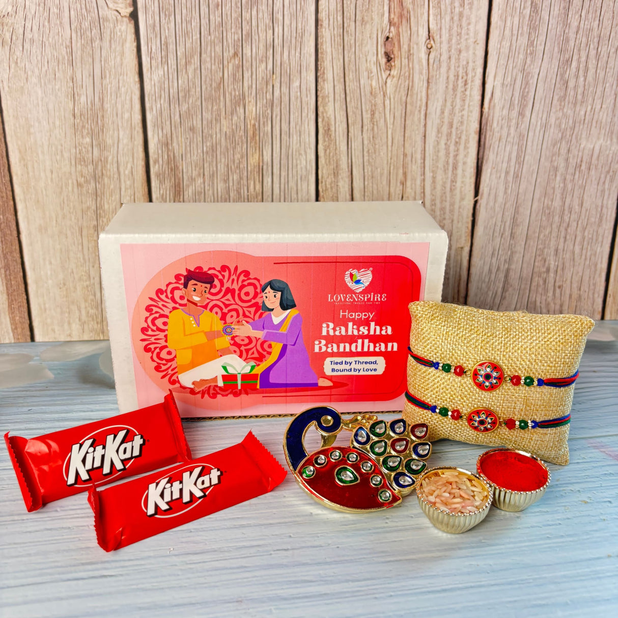 Gold-colored peacock-shaped decorative tray with red and green enamel accents in designer rakhi gift hamper set for brother and bhabhi