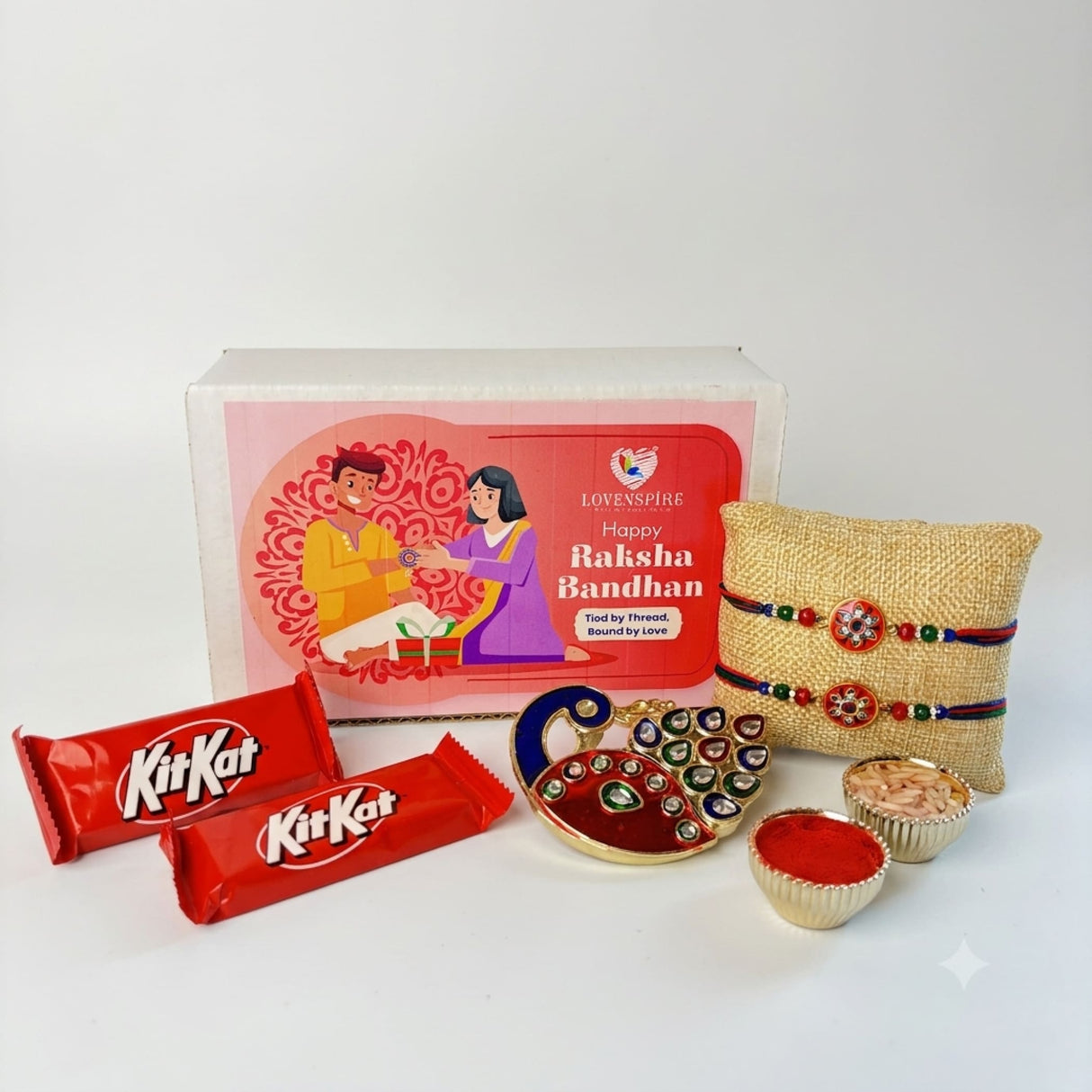 Gold-colored peacock-shaped decorative tray with red and green embellishments in designer rakhi gift hamper set for brother and bhabhi