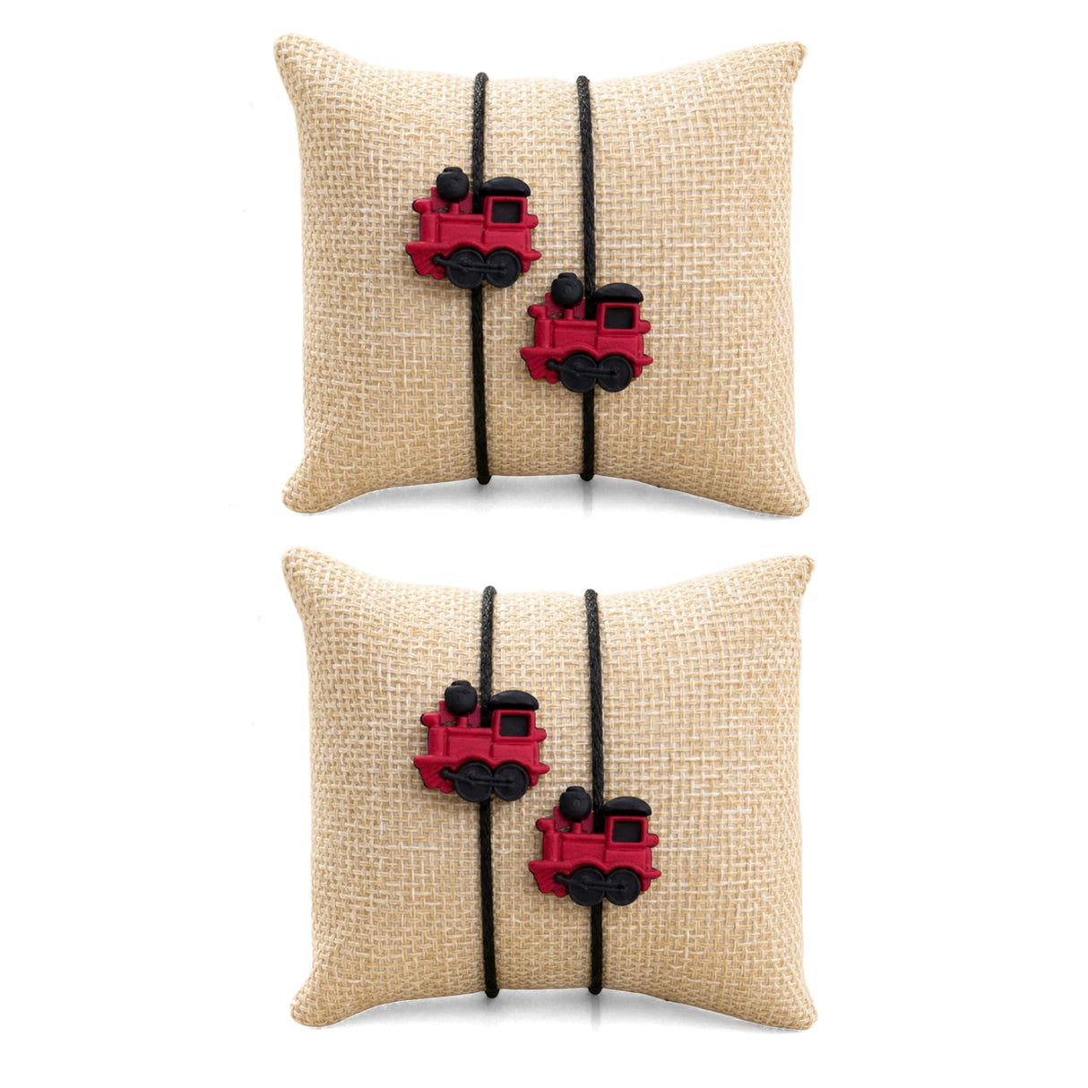 Beige burlap pillow with two red plastic train charms and black cord ties in cartoon rakhi for brother set