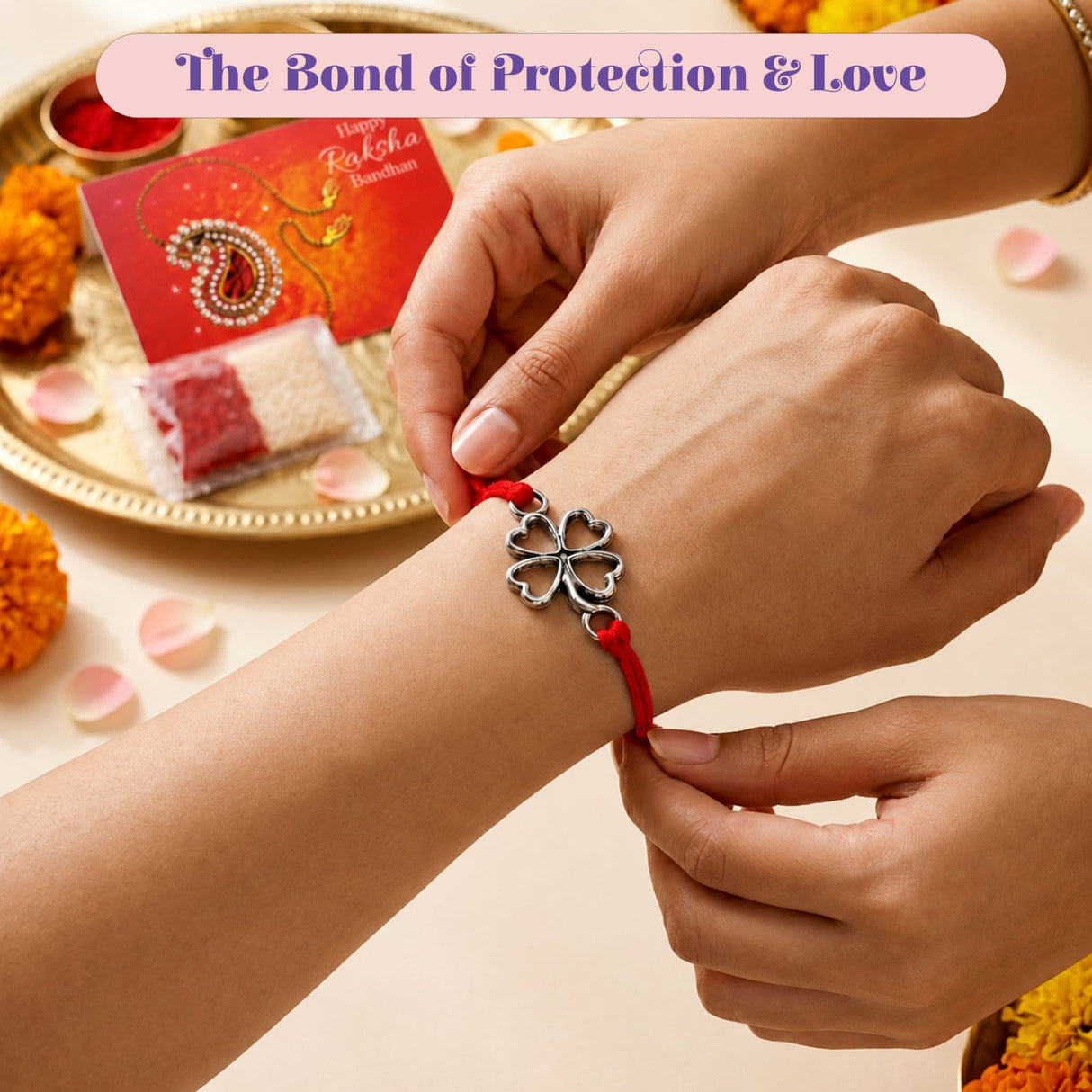 A silver four-leaf clover charm rakhi bracelet with red cord for traditional Raksha Bandhan gifting and good luck