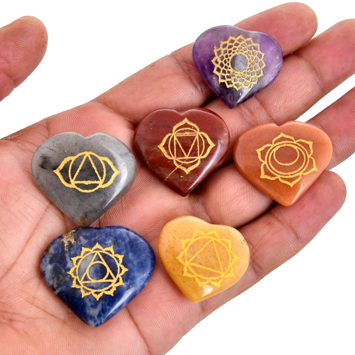 Seven heart-shaped chakra stones in a chakra balancing meditation kit display