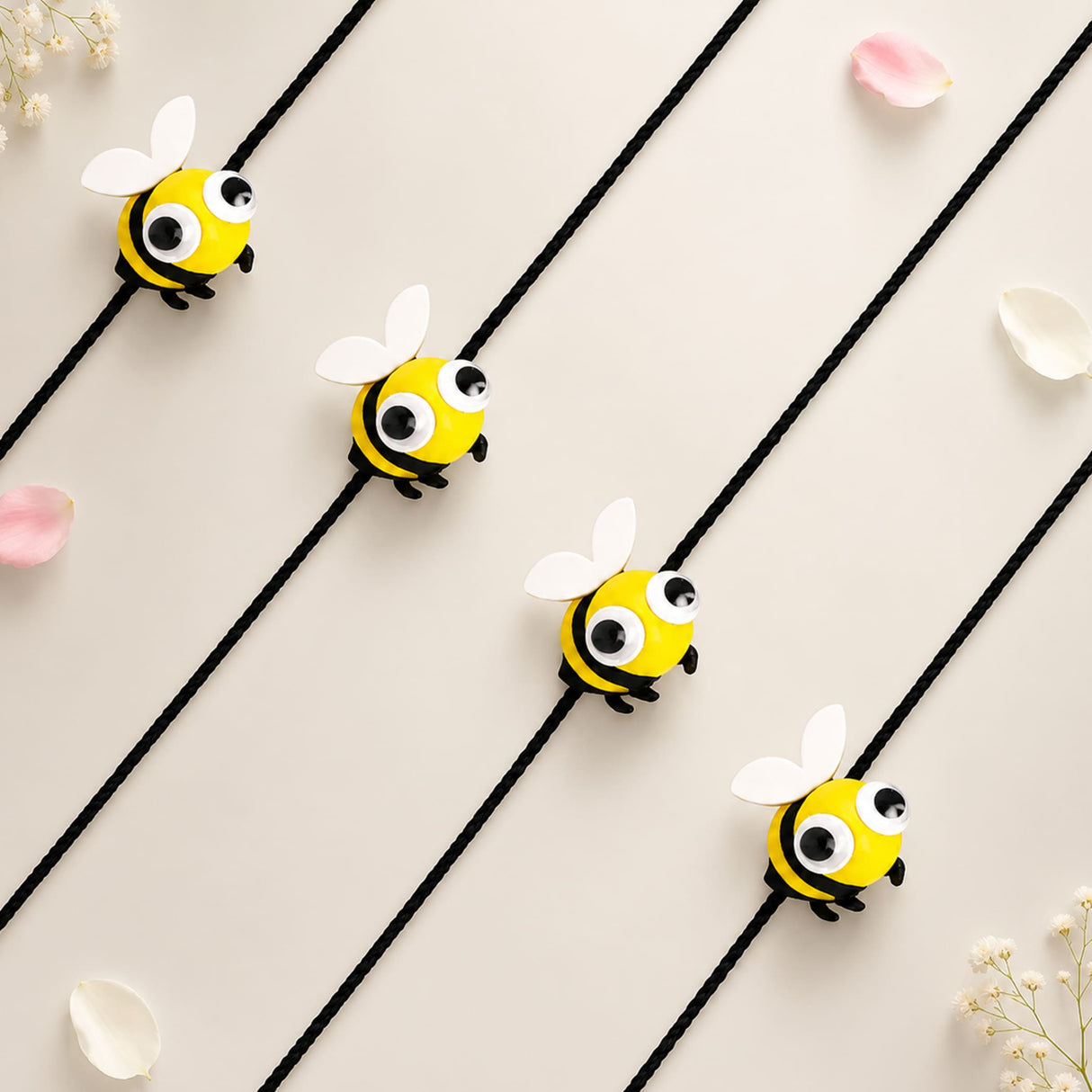 Yellow and black bee-shaped cartoon animal rakhi with white wings and googly eyes on black elastic cords for kids gift