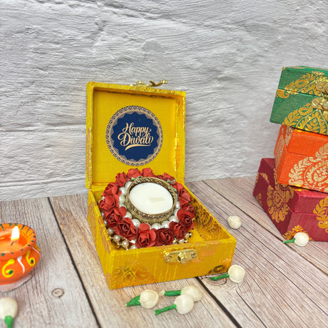 Yellow Diwali gift box with Happy Diwali message, decorative candle, flowers, and pearls