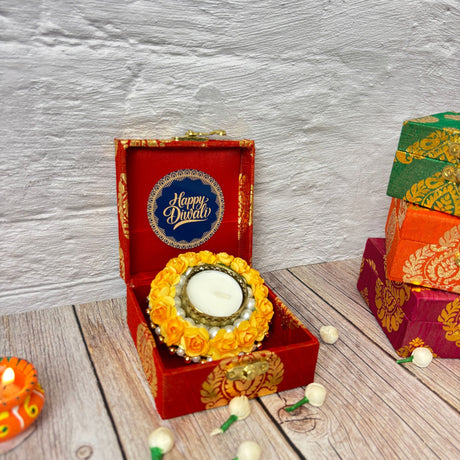 Red decorative box with yellow floral candle holder and white candle for Diwali gift