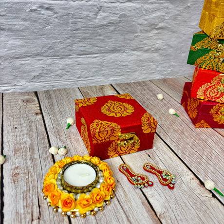 Red square gift box with gold floral designs and clasp for Diwali and Indian festivals