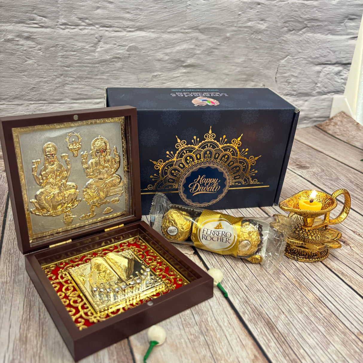 Diwali gift set with religious idol, decorative candle holder, and chocolates for festival gifting