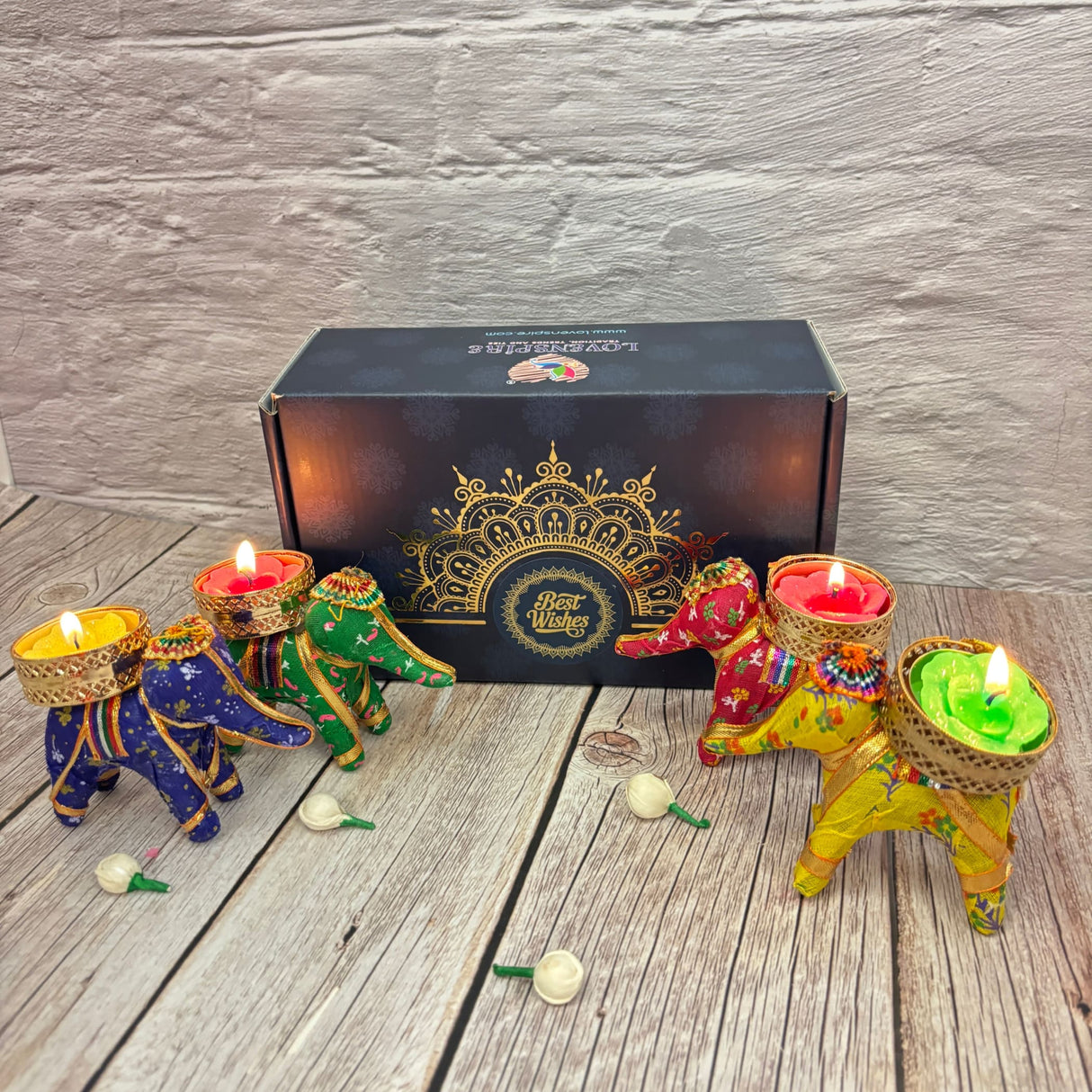 Colorful elephant-shaped tealight candle holders with lit candles in decorative gift box