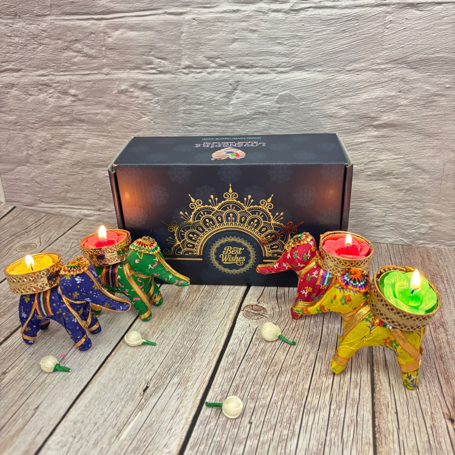 Colorful elephant-shaped tealight candle holders with lit candles in decorative gift box