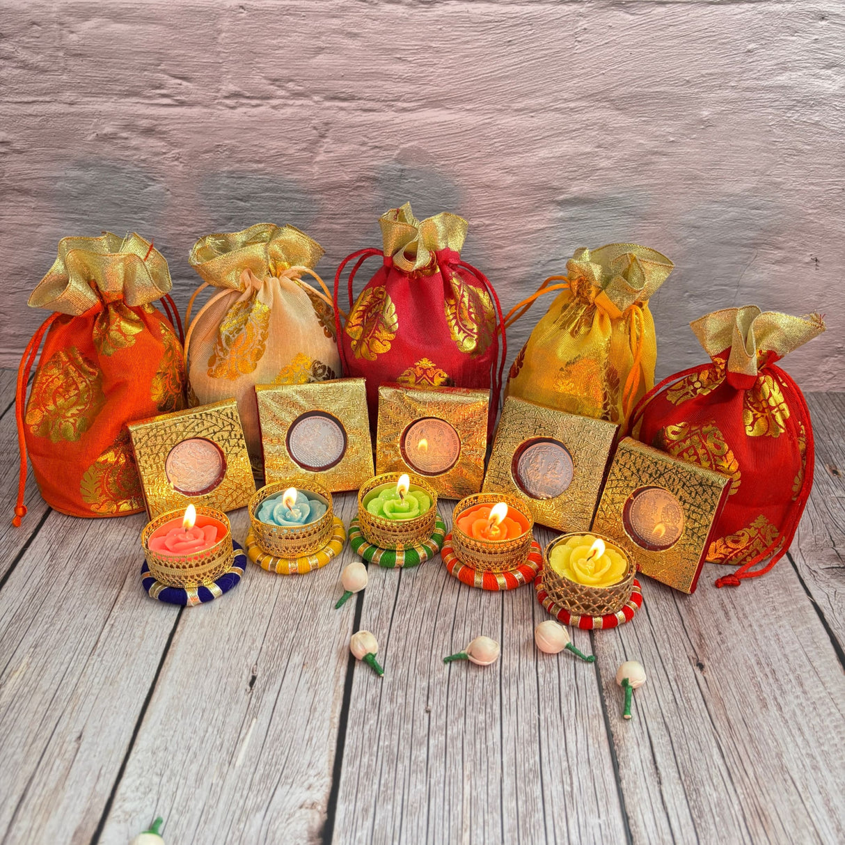 Colorful drawstring gift bags and decorative tea light candles for Diwali celebrations