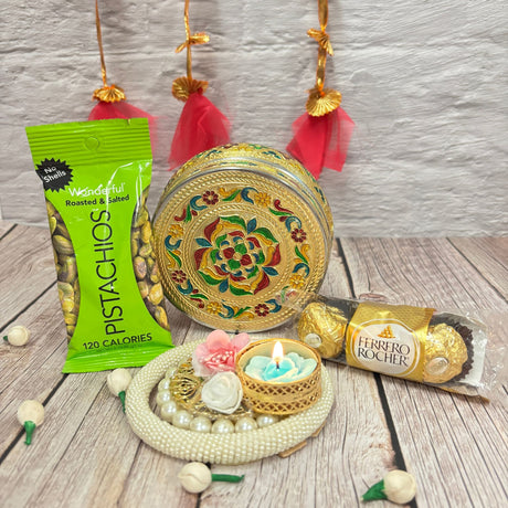 Festive Diwali gift hamper with decorative box, pistachios, chocolates, and candle on pearl tray