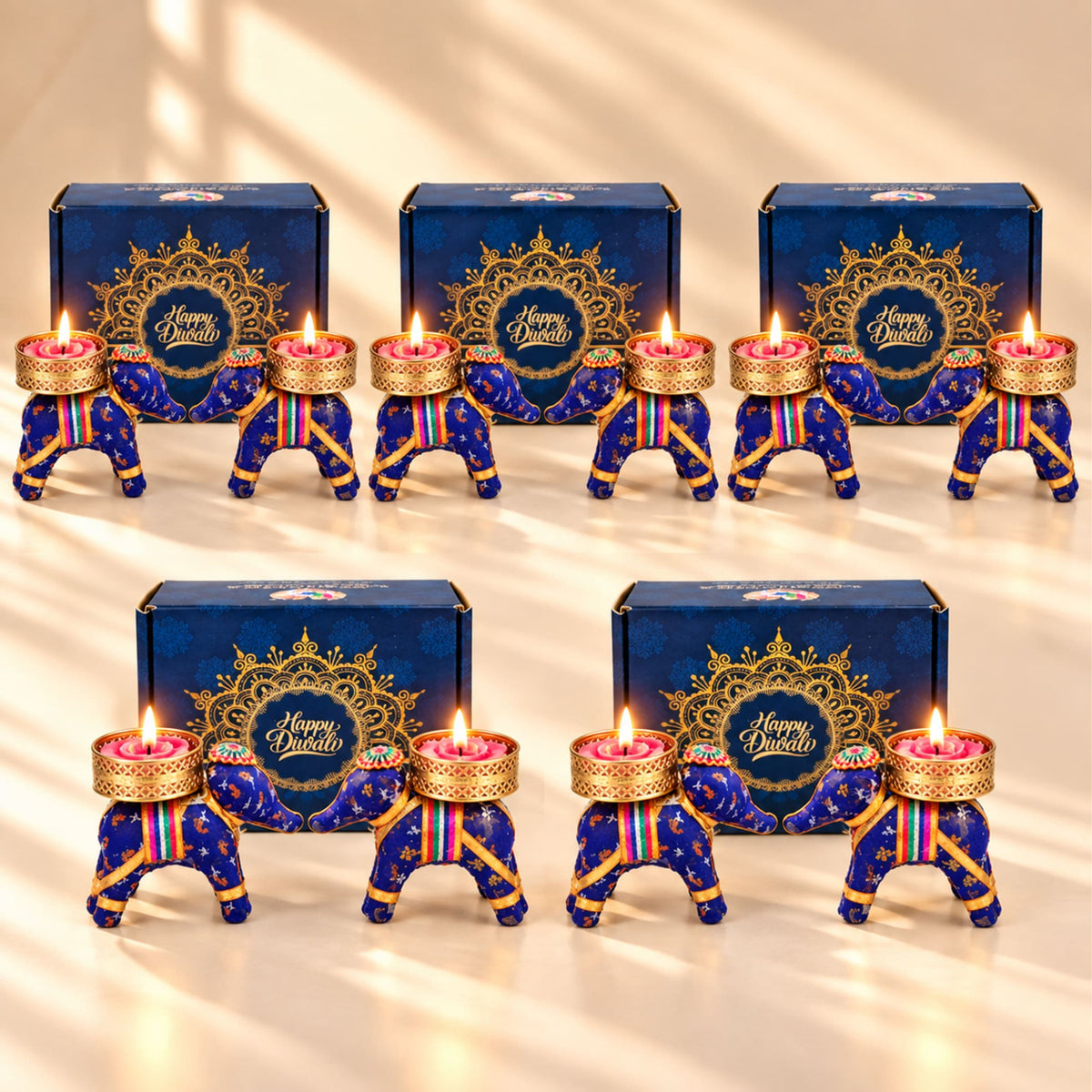 Blue elephant-shaped diwali oil lamps with gold accents and rainbow stripes in handmade indian festival gift hamper