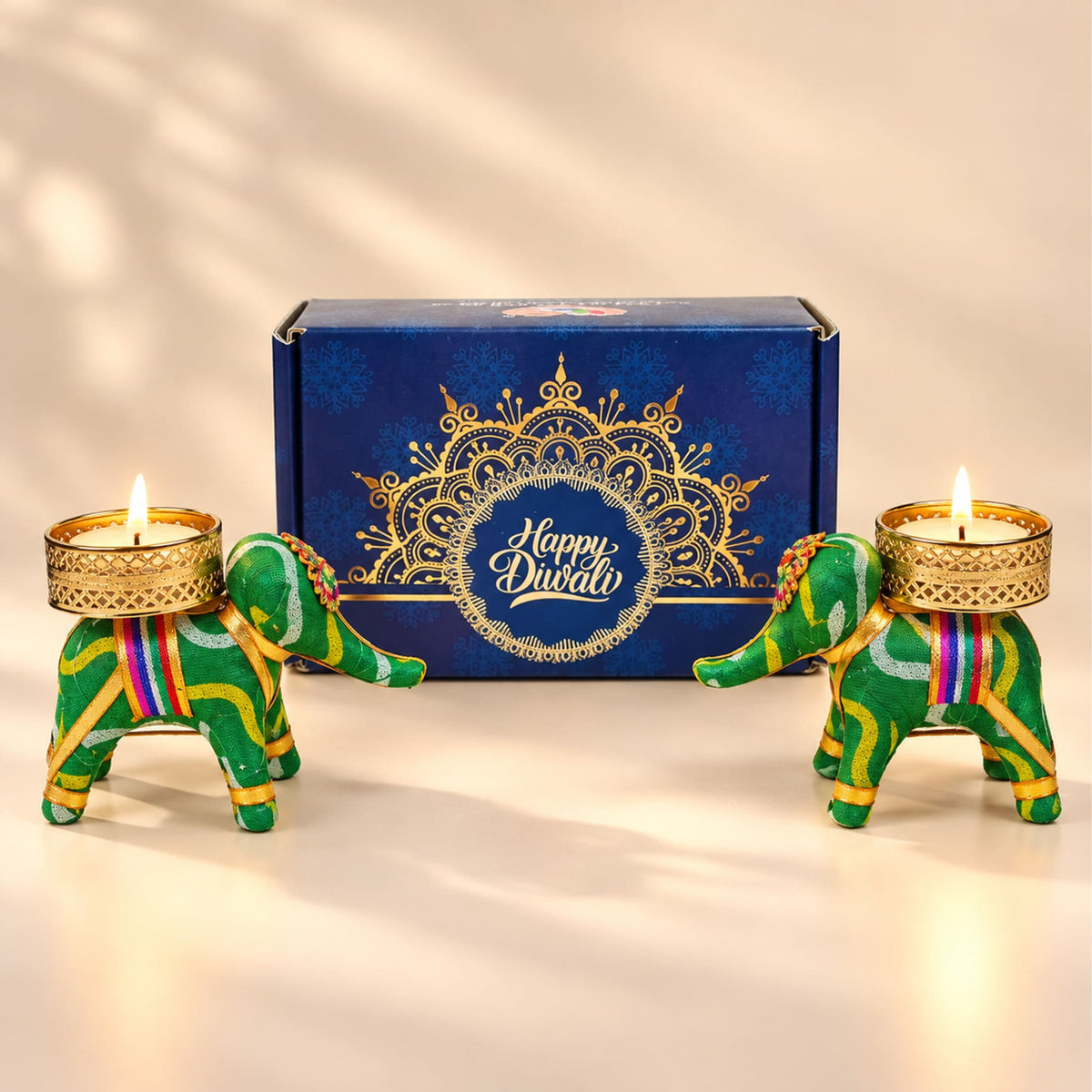 Green elephant-shaped candle holders with gold-trimmed bases and colorful stripes for diwali gift hampers