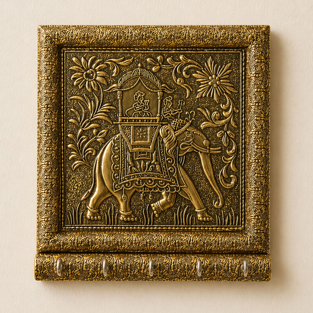 Golden ornate wall-mounted key holder with intricately engraved elephant and floral scrollwork for home decor and organization