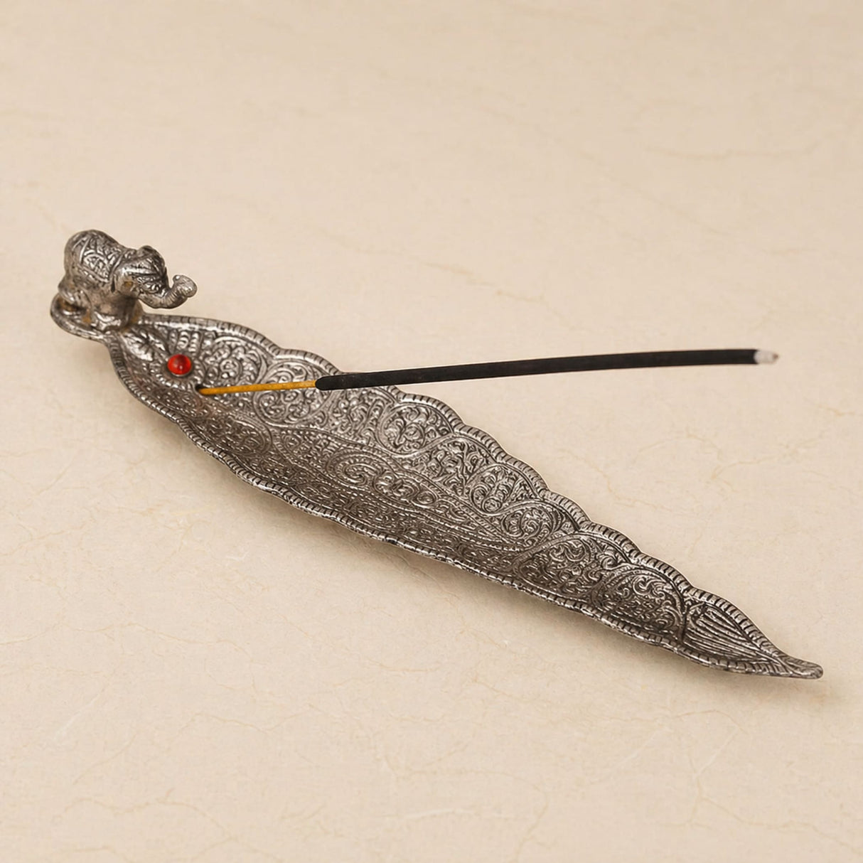 Silver elephant-themed incense holder with intricate floral engravings and red gemstone accent for housewarming gift