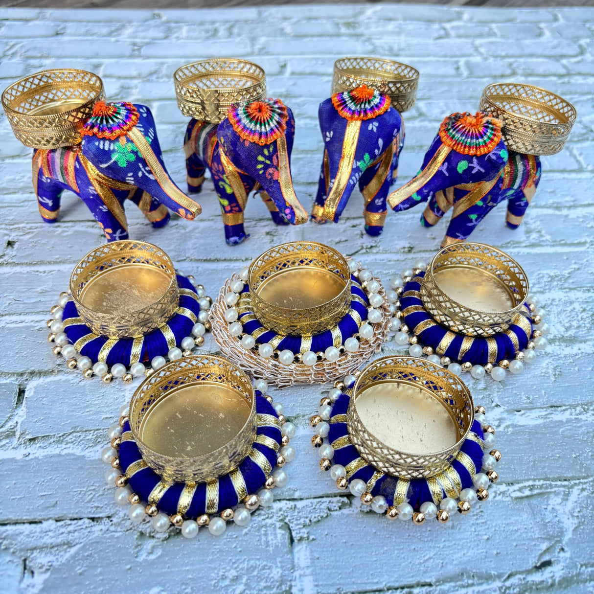 Decorated blue and gold elephant figurines with pearl accents and circular tealight holders