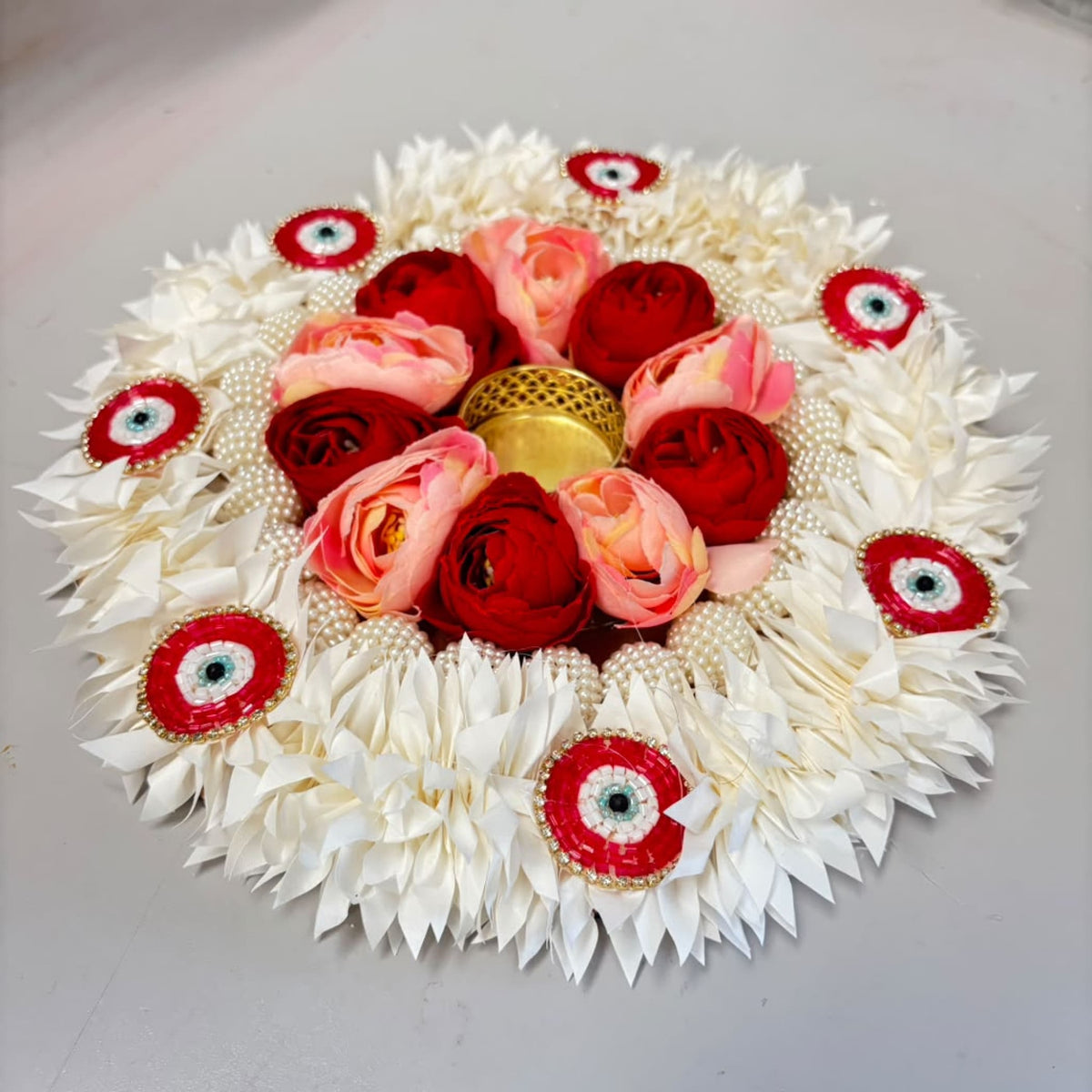 Decorative floral rangoli mat tealight candle holder with white pink and red artificial flowers and golden pearl centerpiece