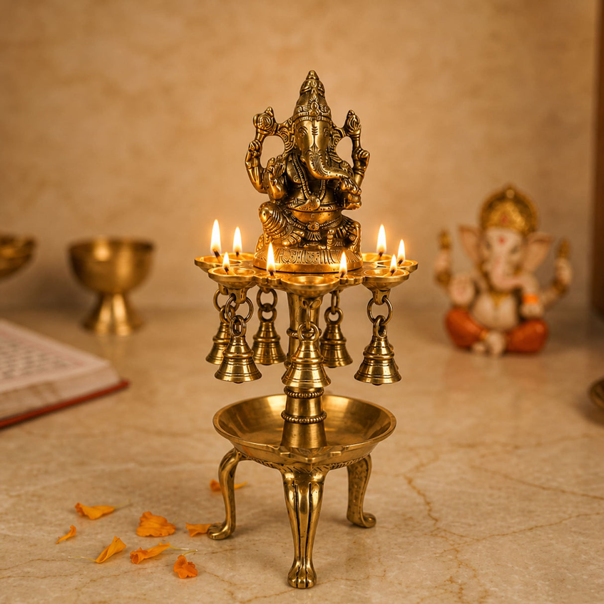 Golden brass ganesha oil tall diya with five lit candles and hanging bells for diwali and altar temple decor