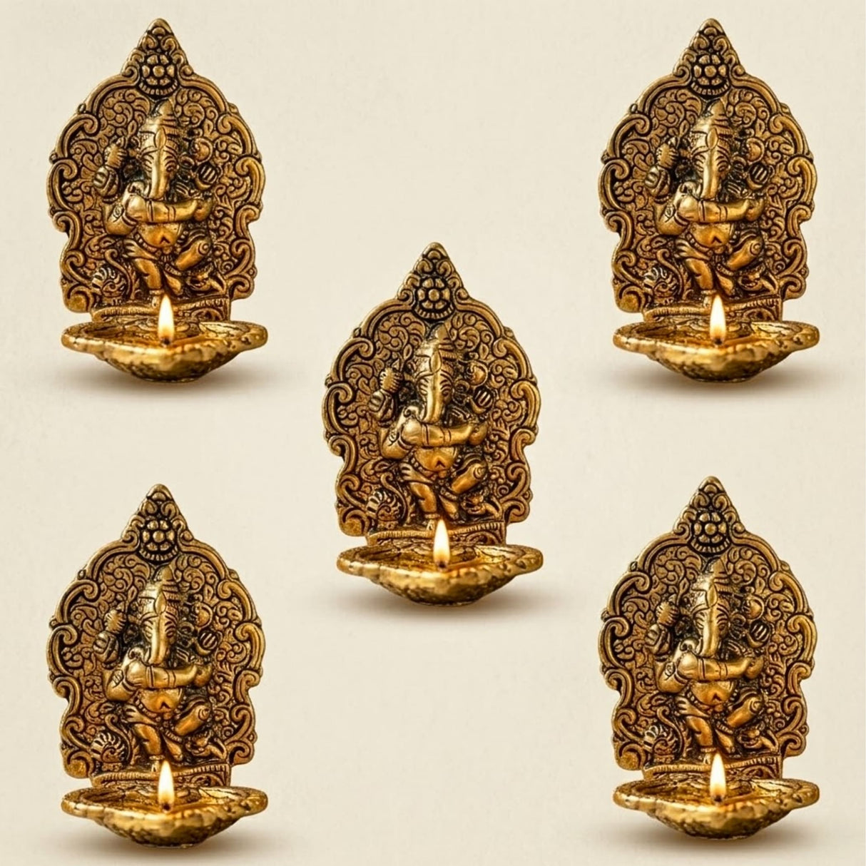 Golden brass ganesha diya oil lamps with intricate carvings and lit candles for puja and diwali decor