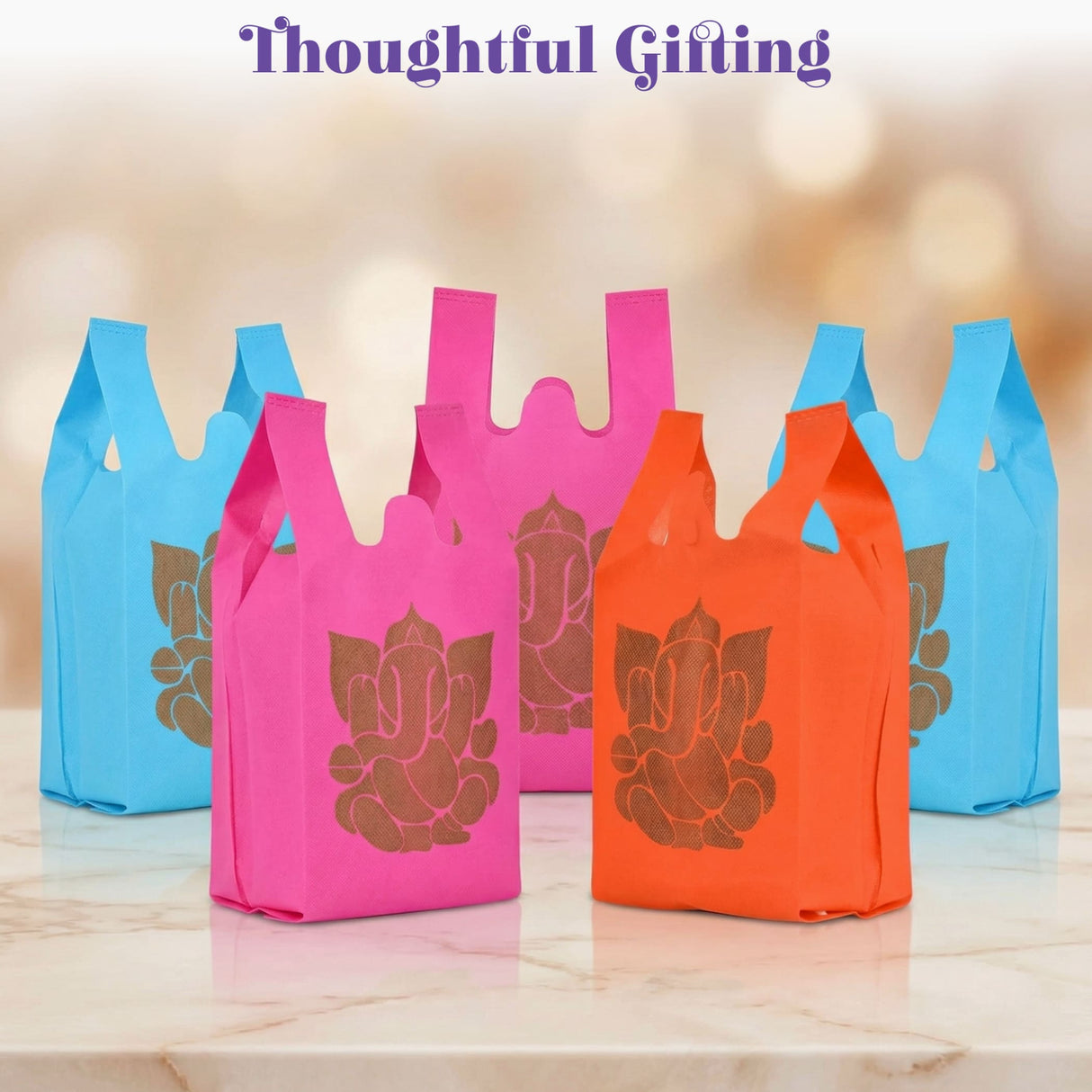 Brightly colored pink orange and blue non woven reusable gift bags with golden Ganesha print for Indian wedding favors