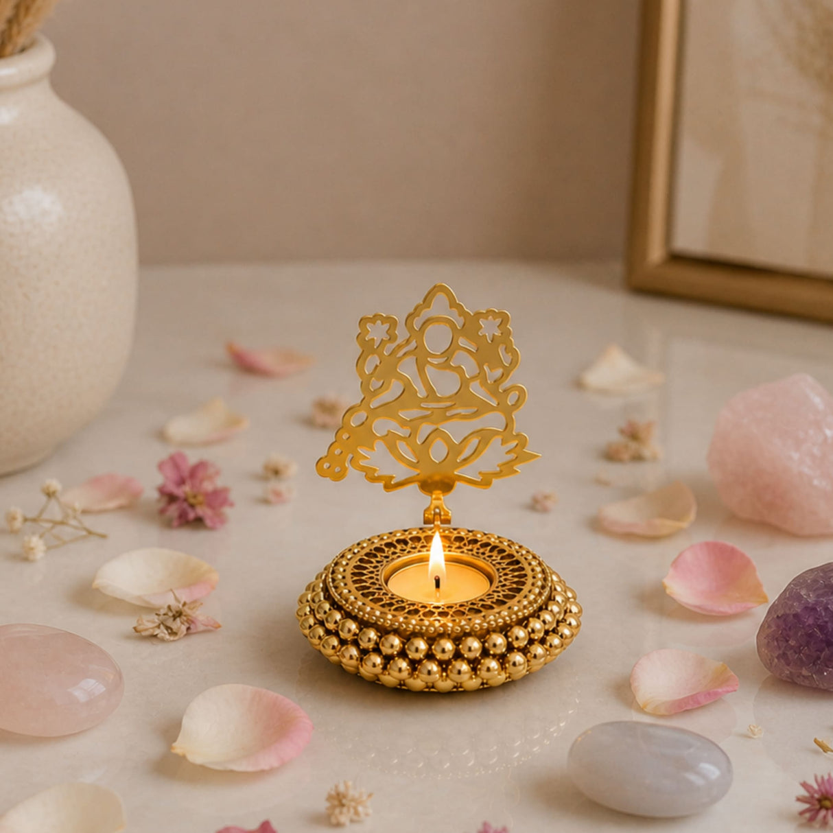 Golden ornate tealight candle holder with intricate filigree, beaded base, and seated deity motif for festive decor