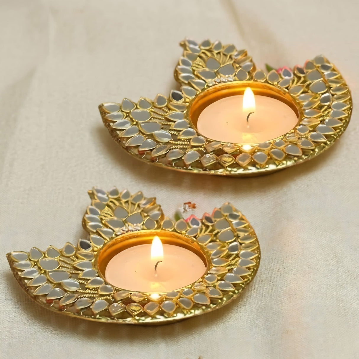 Gold-colored metal diya-shaped candle holder with mirrored leaf embellishments for Diwali puja home decor