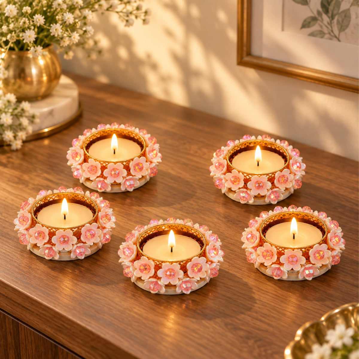Decorative round gold-tone tealight candle holders with white floral design pink centers and crystal embellishments