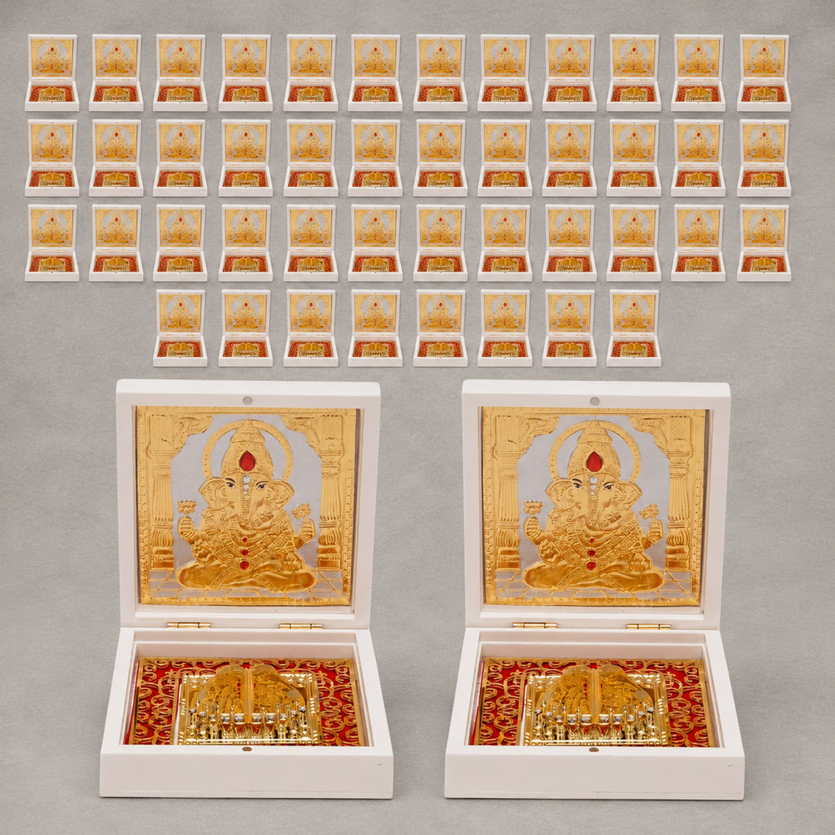 Gold plated ganesh deity figurine set in ornate white boxes with red and gold decorative interiors for home temple and office decor